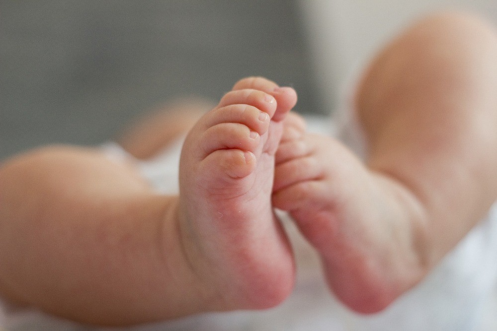 Eine Nahaufnahme der Füße eines Babys während einer Craniosacral-Osteopathie-Sitzung mit Susanna Herrgesell.